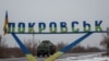 FILE PHOTO: A military vehicle passes by a road sign that reads 'Pokrovsk’ near a front line in the Donetsk region