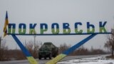 FILE PHOTO: A military vehicle passes by a road sign that reads 'Pokrovsk’ near a front line in the Donetsk region