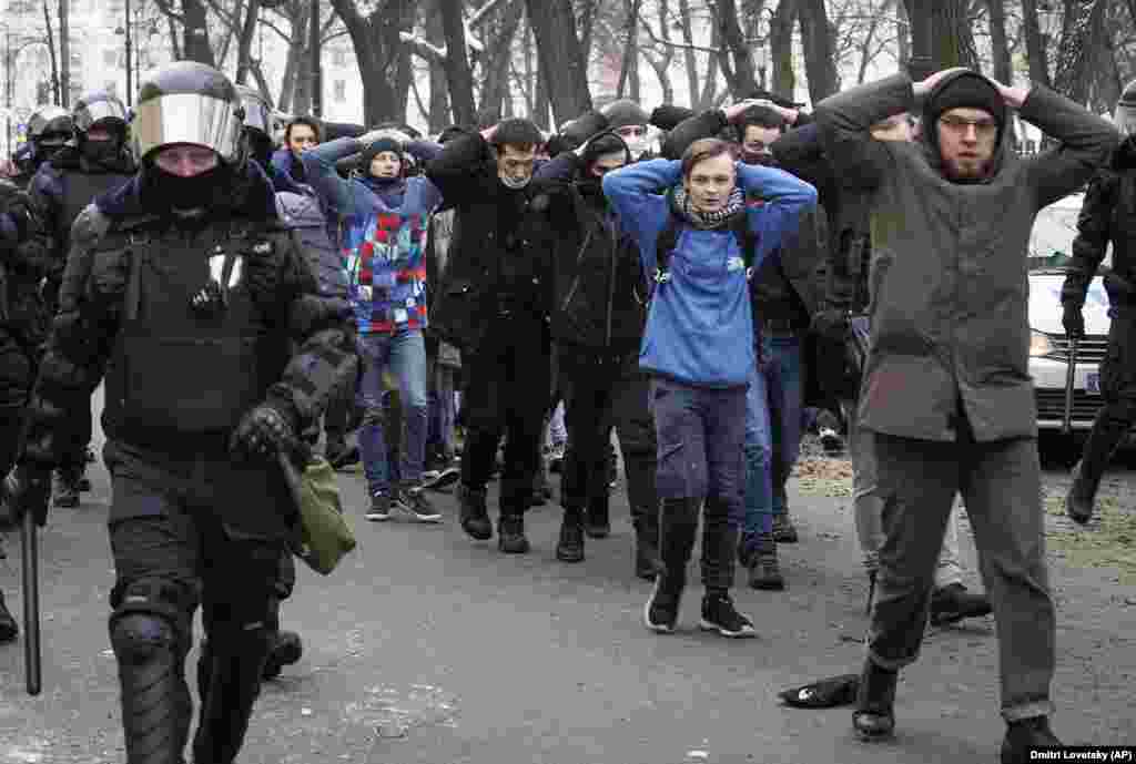 RUSSIA -- Detained protesters walk escorted by police during a protest against the jailing of opposition leader Alexei Navalny in St. Petersburg, Russia, Sunday, Jan. 31, 2021. 
