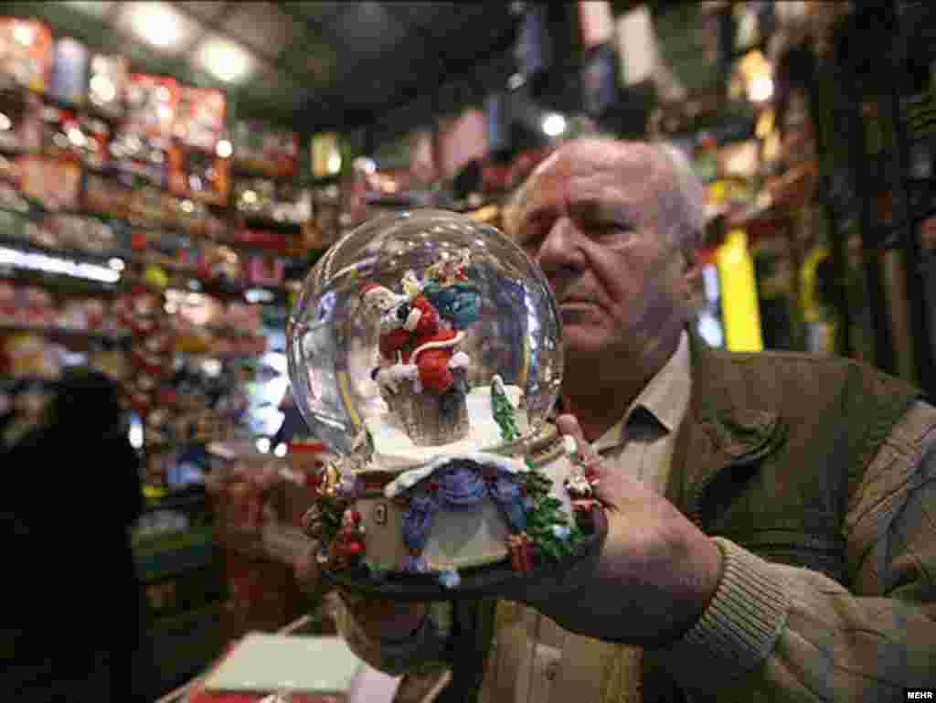 A man inspects a Santa Claus snowglobe in a Christmas shop in Tehran. - Photo by Mehr
