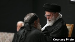Khamenei speaks to eulogist Mahmud Karimi during a mourning ceremony commemorating the death anniversary of the Prophet Muhammad's grandson, Hussein.