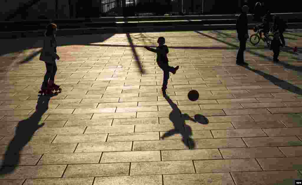 Children play as the sun sets on a public square in Pristina, Kosovo, on March 21. (AFP/Sergei Gapon)