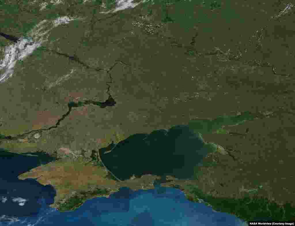 By day, NASA satellites have captured other momentous effects of Russia's ongoing war on Ukraine.These images of southeastern Ukraine and western Russia that were made on June 14, 2012 and June 6, 2026 highlight the disappearance of the water reservoir (center left) that stretched northeast of the Kakhovka Dam on Ukraine's Dnieper River.The dam was destroyed on June 6, 2023 and its reservoir drained into the Black Sea. The 2026 photo also shows a band of green and untended land sweeping from the center of the image up to its top right, where the war's current front line stretches.
