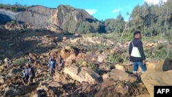  Oamenii se adună la locul unei alunecări de teren în Maip Mulitaka, în provincia Enga din Papua Noua Guinee, la 24 mai 2024.
