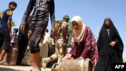 Canisters of gas are distributed to residents of the Iraqi town of Amerli after Iraqi forces broke a monthslong siege of the Shi'ite town by Islamic State fighters on September 2.