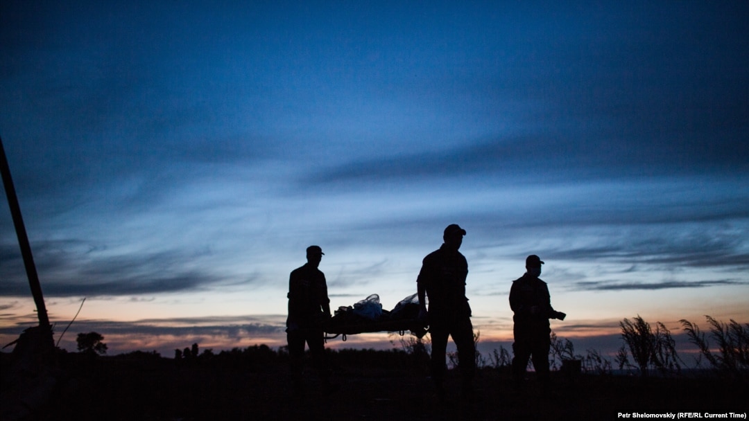 Rescue workers at the MH17 crash site carry away a victim.