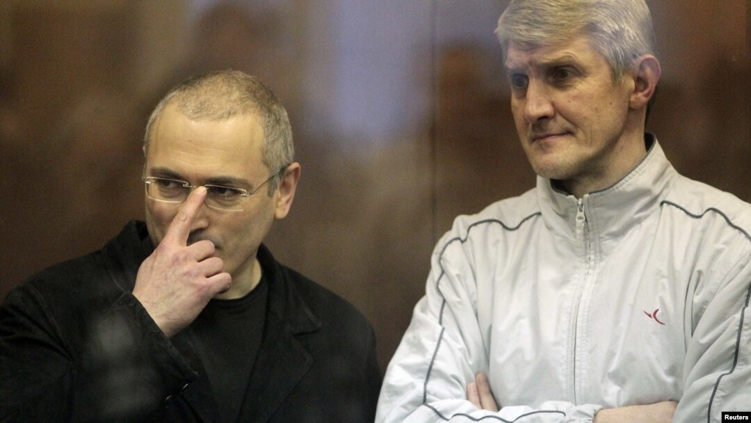 Jailed Russian former oil tycoon Mikhail Khodorkovsky (left) and his business partner Platon Lebedev stand in the defendants' cage before the start of a court session in Moscow in 2010.