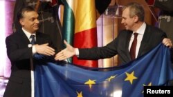 Hungarian Prime Minister Viktor Orban (left) and Belgian Prime Minister Yves Leterme hold the European flag at the Presidency handover ceremony in Budapest on January 6.