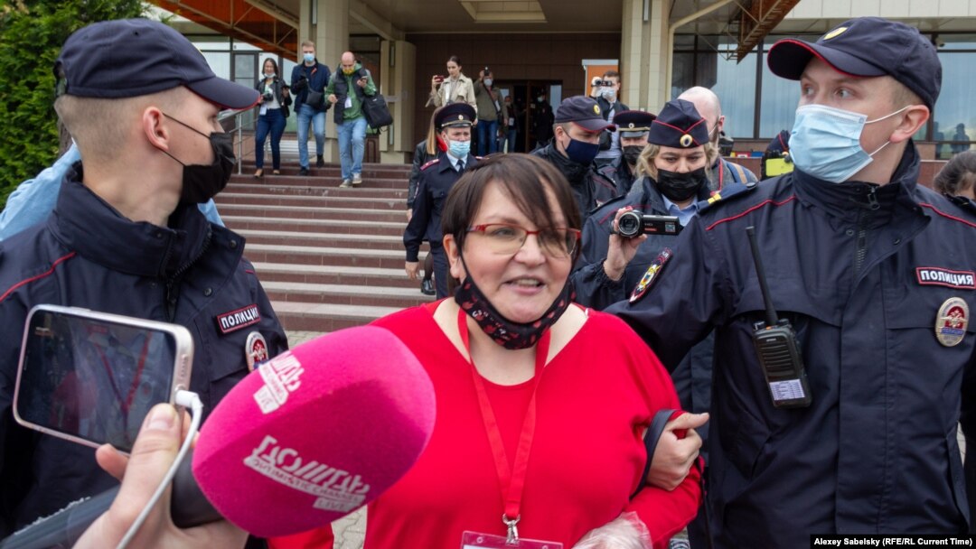 Former municipal deputy Yulia Galyamina in led out of the hotel in Novgorod on May 22. 