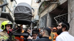 Israeli emergency personnel carry a stroller at the site of a missile strike in Bnei Brak, Israel, on April 1.