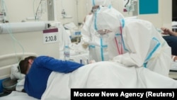 Medical specialists take care of a patient at the temporary hospital set up in the automobile shopping center in Moscow on October 30.