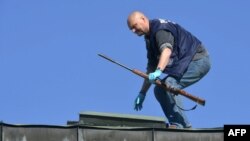 A police officer picks up the 308 calibre rifle used in multiple shootings by a gunman in Hyvinkaa, Finland, on May 26.