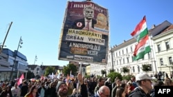 Jedan od učesnika Pridea nosi transparent s porukom: "Zagovornik rata (mađarski premijer) Viktor Orban, lider FIDESZ-a koji mrzi Mađare", Pečuj, 4. oktobra 2025.