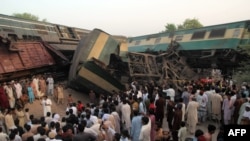 Pakistani bystanders gather at the site of the collision of two trains on the outskirts of Multan on September 15.