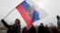 A woman holds a Russian flag on a central square in Sevastopol, the Crimean capital, on March 16.