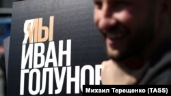 "Медуза" тілшісі Иван Голуновтың есімі жазылған постер жанында тұрған азамат. 