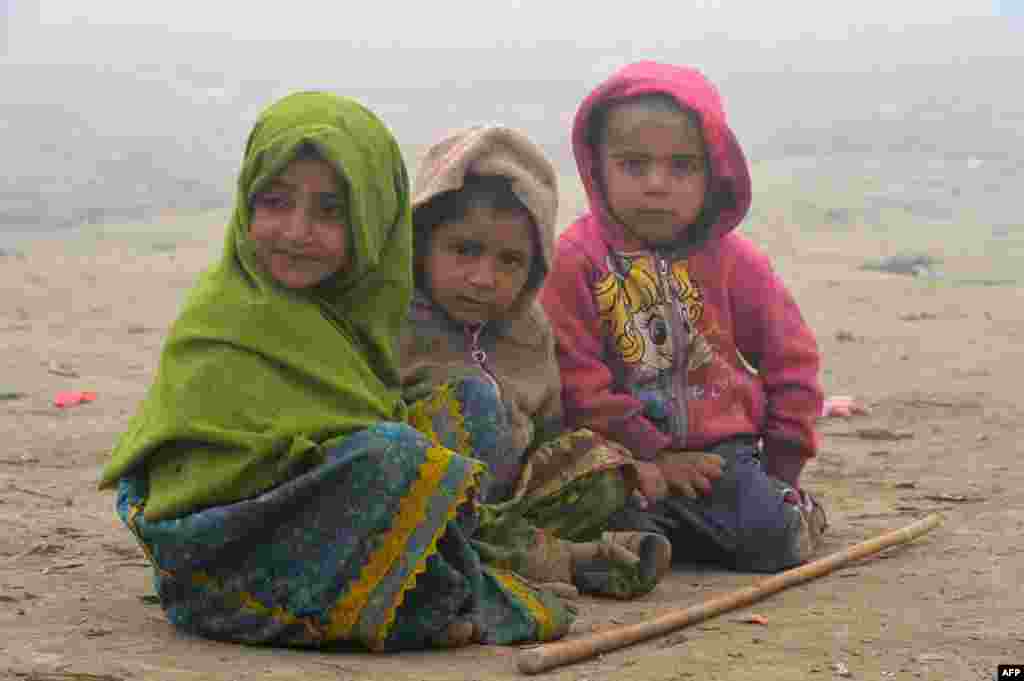 Young homeless children sit on the ground during a foggy day in Peshawar, Pakistan. (AFP/A. Majeed)