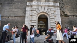 Посетители на Ватиканските музеи показват зелените си пропуски на служител на реда