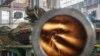 Ukraine -- A Ukrainian worker looks through the barrel from inside a tank turret at the Kharkiv's Armored Plant where Ukrainian T-80 tanks are modified, in Kharkiv, July 13, 2015