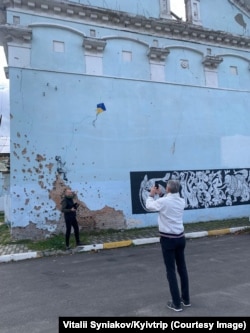 Tourists at the war-damaged House of Culture in Irpin