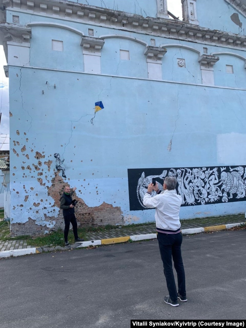 Turistët në Shtëpinë e Kulturës të shkatërruar nga lufta në Irpin.