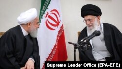 File photo - Iranian supreme leader Ayatollah Ali Khamenei (R) speaks with President Hassan Rohani during a meeting with members of Iranian Assembly of Experts in Tehran, March 14, 2019