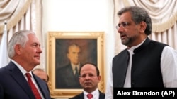 U.S. Secretary of State Rex Tillerson (left) is greeted by Pakistani Prime Minister Shahid Khaqan Abbasi (right) in Islamabad on October 24. 