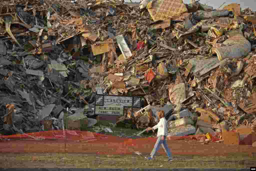 A woman walks past a mountain of debris filling entire city blocks from destroyed homes in the Lakeview section of New Orleans.