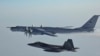 A Russian Tu-142 maritime reconnaissance aircraft (top), top right, is intercepted near the Alaska coastline. (file photo)