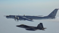 A Russian Tu-142 maritime reconnaissance aircraft (top), top right, is intercepted near the Alaska coastline. (file photo)