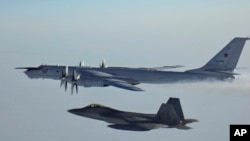 A Russian Tu-142 maritime reconnaissance aircraft (top), top right, is intercepted near the Alaska coastline. (file photo)