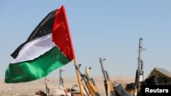 Susținătorii tribali ai grupării Houthi din Yemen flutură un steag palestinian și își ridică armele în timpul unui protest față de loviturile recente ale SUA asupra țintelor Houthi, lângă capitala Sanaa.
