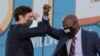 Democratic candidates for Senate Jon Ossoff (L) and Raphael Warnock (R) bump elbows on stage during a rally with US President-elect Joe Biden