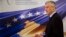 President Hashim Thaci stands in front of a banner marking the 10th anniversary of Kosovo's independence during an interview with the Associated Press in Pristina on February 14.