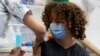 Egy tizenéves kap oltást koronavírus ellen Izraelben. A 12–15 éveseket is arra biztatják, hogy oltassák be magukat, miután a korábbinál fertőzőbb delta-variáns miatt romlik a járványhelyzet Izraelben. Tel-Aviv, 2021. június 21.