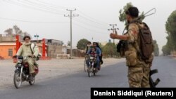 A member of the Afghan special forces directs traffic during an operation in Kandahar Province on July 13.