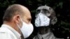 Director of Prague Zoo Miroslav Bobek wearing a face mask stands next to a statue of Prague Zoo founder Jiri Janda, as the Czech government shut zoos, sports and culture venues for two weeks to slow down the spread the coronavirus disease 