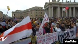 Падчас кананізацыі Яна Паўла ІІ у Ватыкане лунае бел-чырвона-белы сьцяг і відаць транспарант: «На Беларусі Бог жыве!»