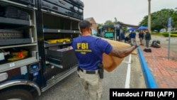 A Federal Bureau of Investigation (FBI) evidence-response team works after a shooting incident at a naval base in Pensacola, Florida, on December 6.