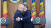 Prim-miniștri Bolojan și Dorin Recean, îmbrățișându-se în timpul unei apariții în fața presei, la Casa Guvernului din Chișnău, pe 23 august 