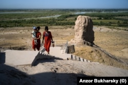 Two Uzbek women climb to the top of the tower of silence.
