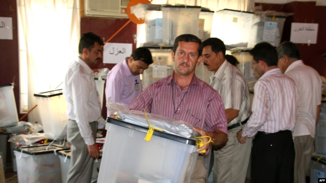 An electoral worker in the northern Kurdish city of Sulaimaniyah carries a sealed ballot box containing votes cast by servicemen and others ahead of election day on July 25.