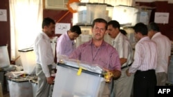 An electoral worker in the northern Kurdish city of Sulaimaniyah carries a sealed ballot box containing votes cast by servicemen and others ahead of election day on July 25.