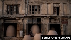 AFGHANISTAN -- An Afghan potter sits among tandoor ovens in Kabul, September 20, 2021