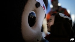 Egy japán kisfiú barátkozik Cseburáskával a 2014-es, Hanjuban tartott Globális Rajzfilmfigura Csúcson.