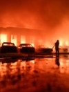 A Ukrainian firefighter battles a blaze at a private enterprise hit by a Russian drone strike in Zaporizhzhya. 