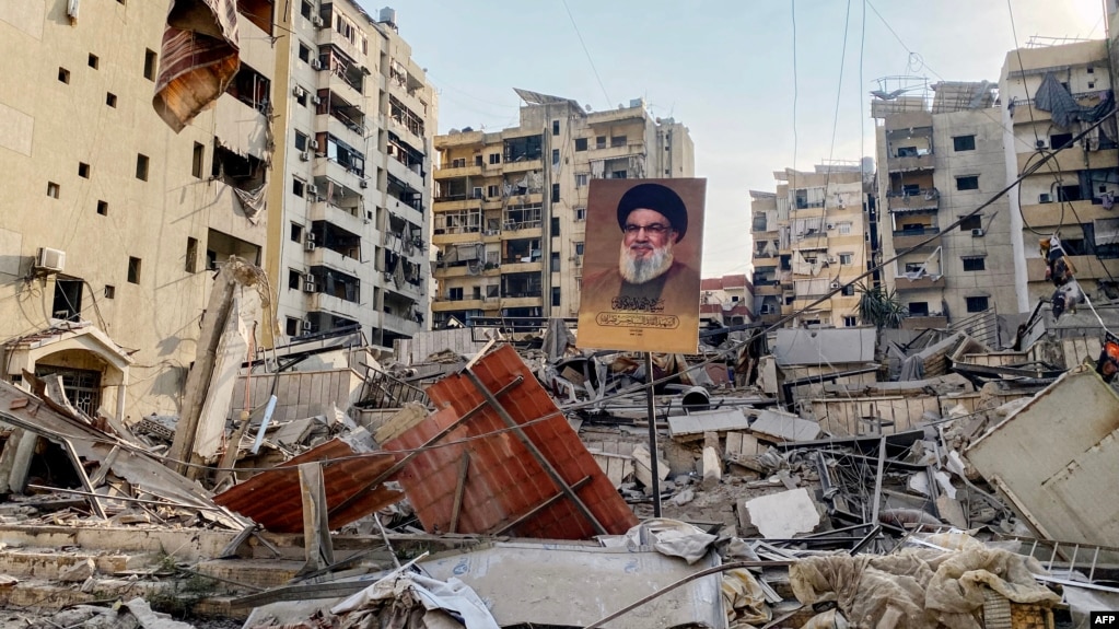 تصویری از حسن نصرالله، رهبر کشتهشدهٔ حزبالله لبنان، در میان ویرانههای ضاحیه، حومه جنوبی بیروت