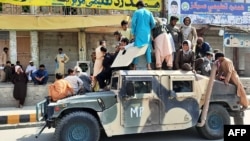 Войници на талибаните са се качили върху брониран автомобил на афганистанските военни