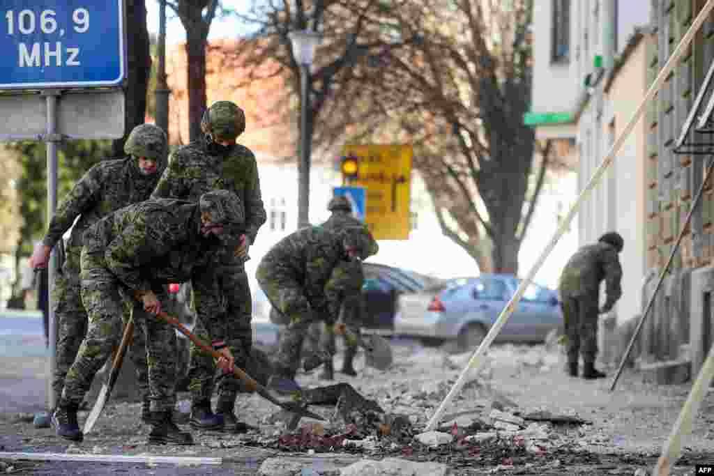 Хрватски војници чистат урнатини покрај оштетените згради во Петриња, на околу 50 километри од Загреб, откако градот беше погоден од земјотрес со јачина од 6,4 степени на 29 декември 2020 година.