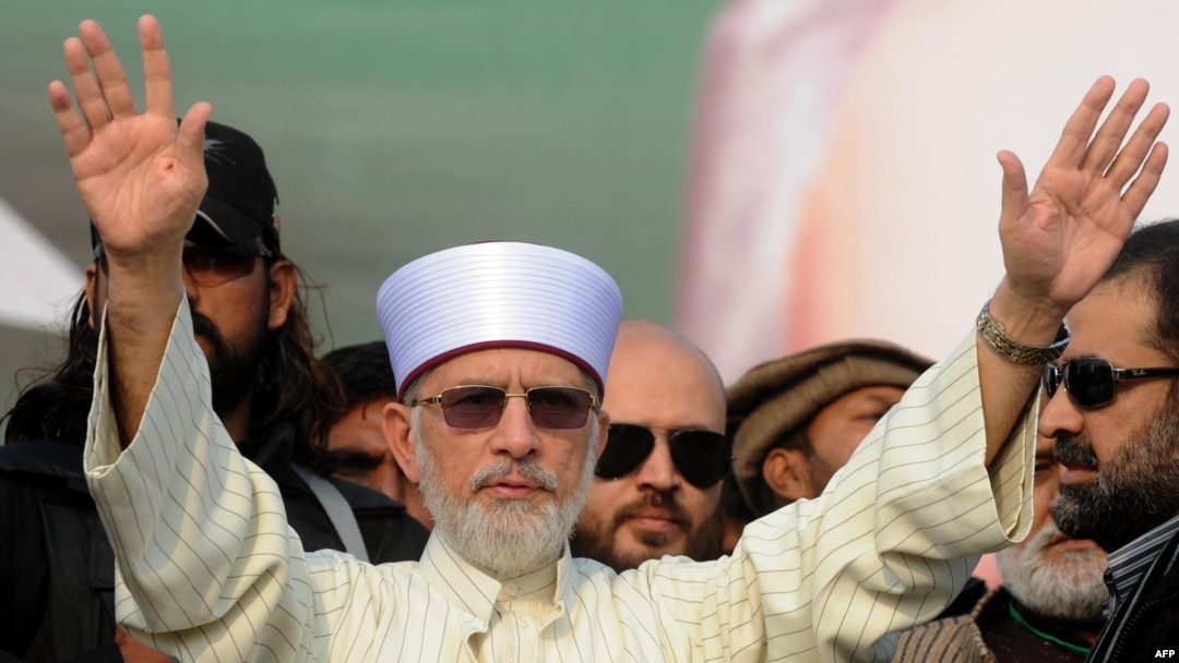 Muhammad Tahir-ul-Qadri waves to supporters on his arrival in Lahore on December 23.